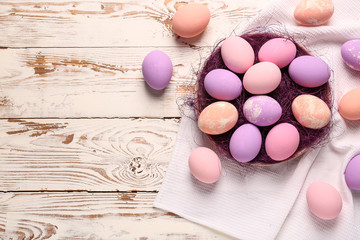 Plate with Easter eggs on wooden table