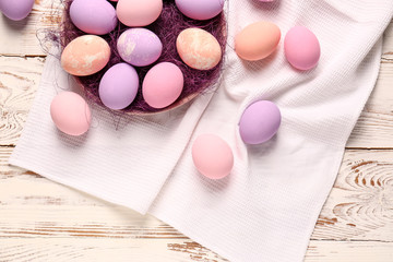 Plate with Easter eggs on wooden table