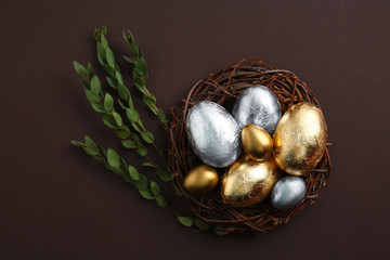 Nest with beautiful Easter eggs on dark background