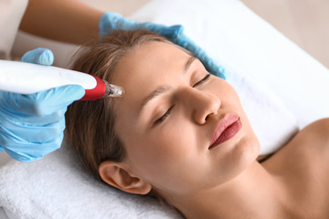 Fototapeta na wymiar Young woman undergoing procedure of bb glow treatment in beauty salon