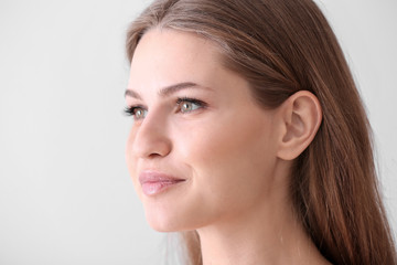 Fototapeta premium Young woman with beautiful eyelashes on light background