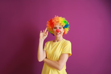 Funny woman with party decor for April Fools' Day on color background