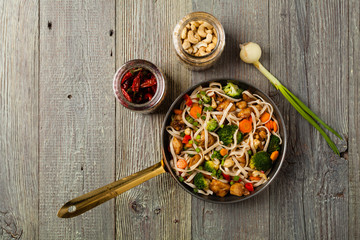 stir-fry pasta with chicken, broccoli and carrots.