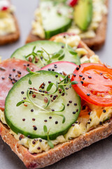 Sandwiches with cream cheese, vegetables and salami.