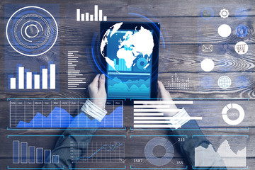 Business workplace with tablet device coffee cup and media graphs and diagrams