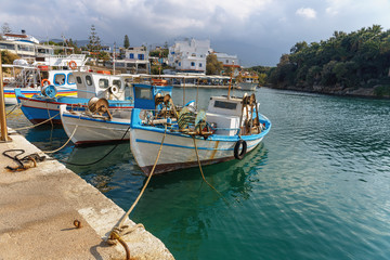 Fototapeta na wymiar view of small fishing boats in a quiet harbor in the greek village of Sissi