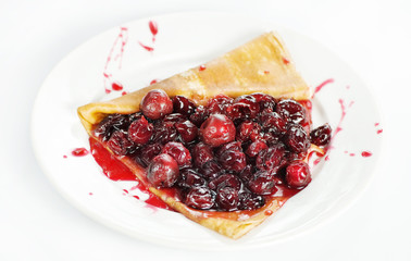 Thin delicious pancake with berry jam on white