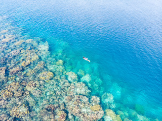 Fototapeta premium Aerial top down people snorkeling on coral reef tropical caribbean sea, turquoise blue water. Indonesia Banyak Islands Sumatra, tourist diving travel destination.