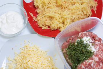 Chopping grated potatoes. Minced meat steaks with potatoes, eggs and cheese. Cooking steps and ingredients.