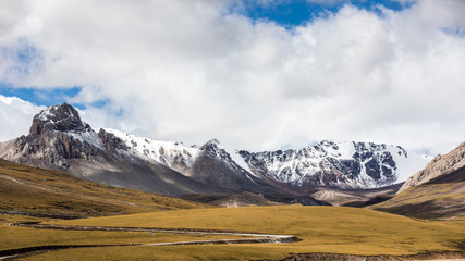Fototapeta premium Nature landscape of snow mountains under clear blue sky with clouds