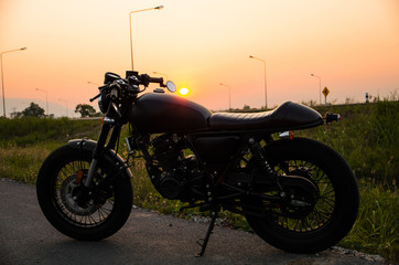 vintage motorcycle cafe racer style with sunset scene
