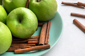 green fresh apples and fragrant cinnamon sticks close up