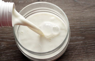 Pouring fresh milk into a glass bowl