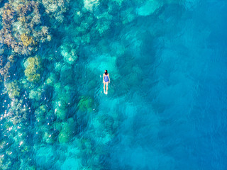 Aerial top down people snorkeling on coral reef tropical caribbean sea, turquoise blue water. Indonesia Banyak Islands Sumatra, tourist diving travel destination.