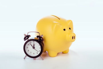 Piggy bank with alarm clock isolated on white background