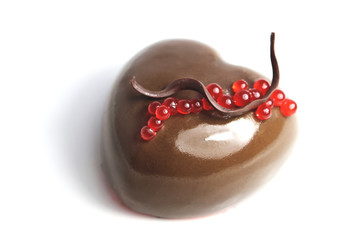 Chocolate heart shaped dessert with red pomegranate juice caviar and chocolate decoration on white background