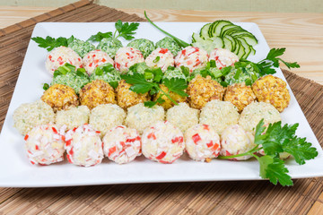 Various salads in the form of balls on square dish