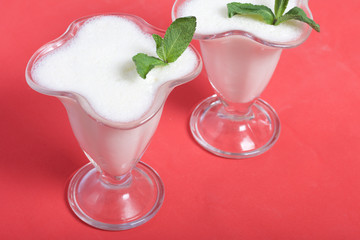 Creamers with sour cream jelly. Decorated with mint leaves.