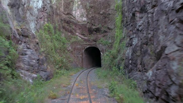 POV of a moving train entering a narrow tunnel