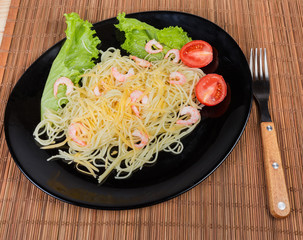 Cooked Spaghetti with shrimps, cheese, tomatoes, lettuce and fork