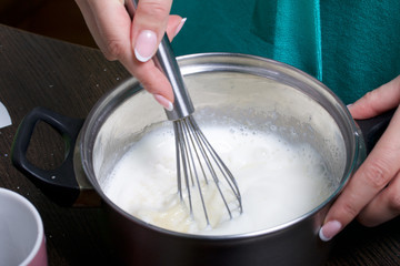 Cooking milk jelly. Cooking a cake of biscuit crumbs and milk jelly. On the surface of the table are the ingredients and cooking utensils.