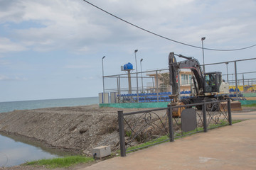 Fototapeta na wymiar Excavator on the reclamation land. excavator at sea beach shore to renovate and relocation prepare for development