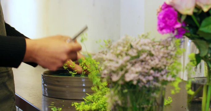Florist making a beautiful flower decoration with oasis floral foam.