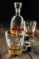 Whiskey glass and bottle on the old wooden table