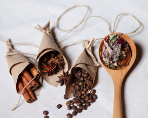 Tea in wooden spoon, coffee cinnamon and anise in craft paper cornets. Rustic rope. Aromatherapy in the kitchen