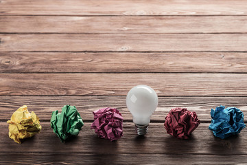 Ideological concept with wastepaper light bulb on wooden table