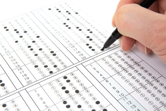 Man is filling OMR sheet handing with pen.