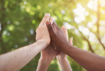Business team giving group high five in park