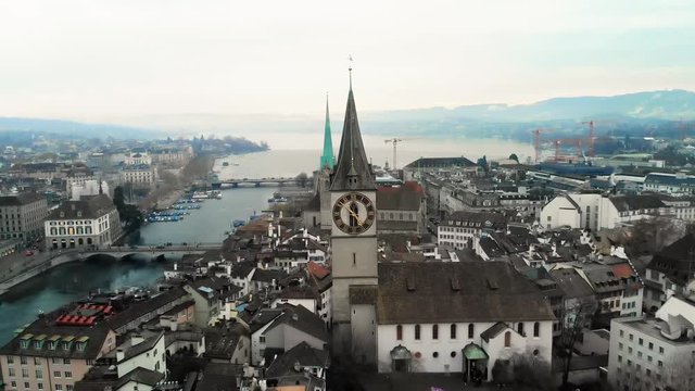 Aerial view of Zurich rooftops and a Church of St. Peter with a clock tower The city of Zurich, a global center for banking and finance, lies at the north end of Lake Zurich in northern Switzerland. 