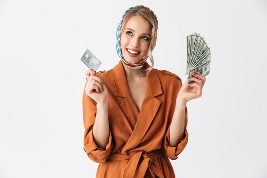 Beautiful Happy Young Woman Wearing Silk Scarf Isolated Over White Background Holding Credit Card And Money.