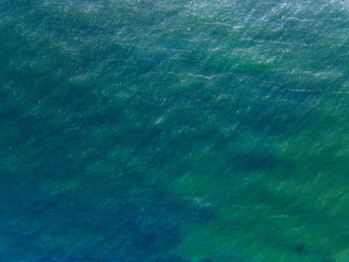 Aerial top view water surface background. Bird eye sea surface photo from drone. Turquoise ocean from above.