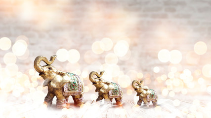 Golden elephant on a wooden table. room, light effect. Beautiful statuette of an elephant on the background.