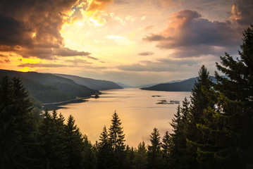 Amazing sunset landscape - big lake , forest, mountains and colorful sky.  Dospat Bulgaria