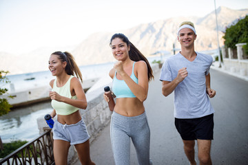 Happy people jogging outdoor. Running, sport, exercising and healthy lifestyle concept