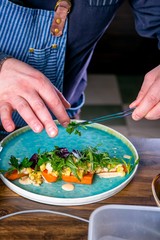 Chef decorates the salad with smoked catfish, carrots and miso sause. Master class in the kitchen. The process of cooking. Step by step. Tutorial. Close-up
