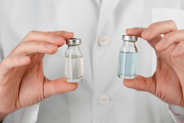 Doctor holding bottles of vaccine