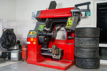 A close-up of the modern tire changer for repairing and repairing alloy wheels stands against the backdrop of a workshop for car repair and tire mounting.The concept of the tire workshop