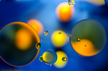 orange and yellow balls on a blue background of oil stains