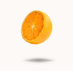 Flying half orange fruit , isolated on white background with shadow. Concept of food levitation