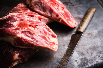 Raw meat with salt and spices on the rustic background. Selective focus.