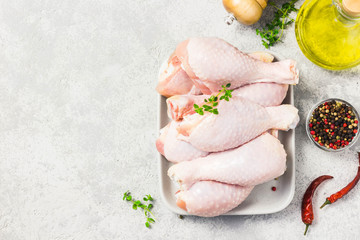 Raw chicken legs, drumsticks on concrete background. Top view, space for text.