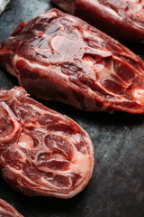 Raw meat with salt and spices on the rustic background. Selective focus.