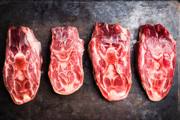 Raw meat with salt and spices on the rustic background. Selective focus.