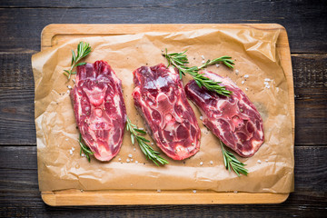 Raw meat with salt and spices on the rustic background. Selective focus.