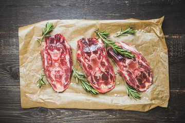 Raw meat with salt and spices on the rustic background. Selective focus.