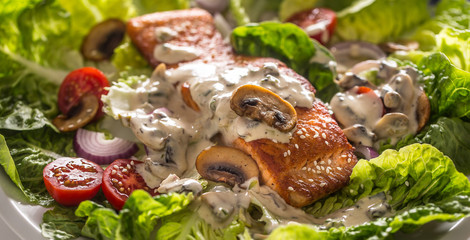 Roasted salmon fillet with fresh vegetable salad tomatoes mushrooms sauce and sesame